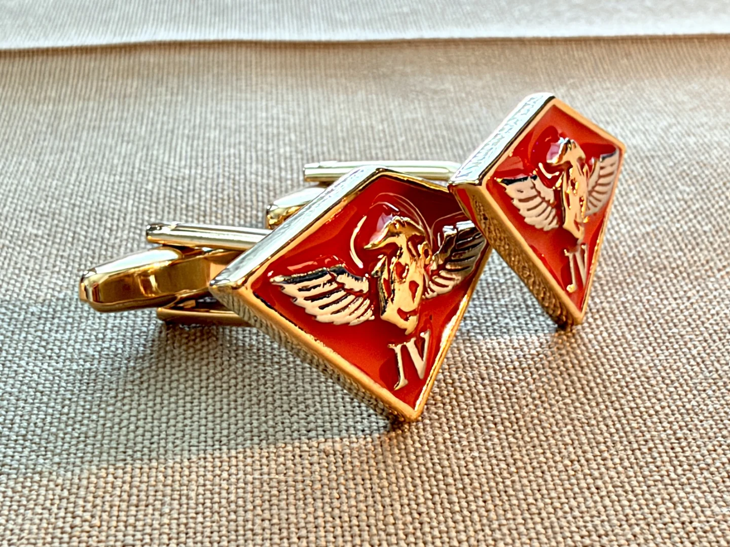 Side angle of actual 4th Marine Aircraft Wing cufflinks showing the gold-tone fastening hardware on khaki fabric
