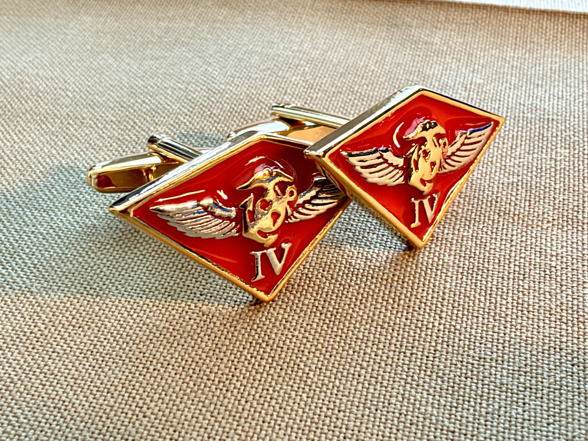 Actual red and gold-tone 4th Marine Aircraft Wing cufflinks photographed on a Marine Corps khaki shirt