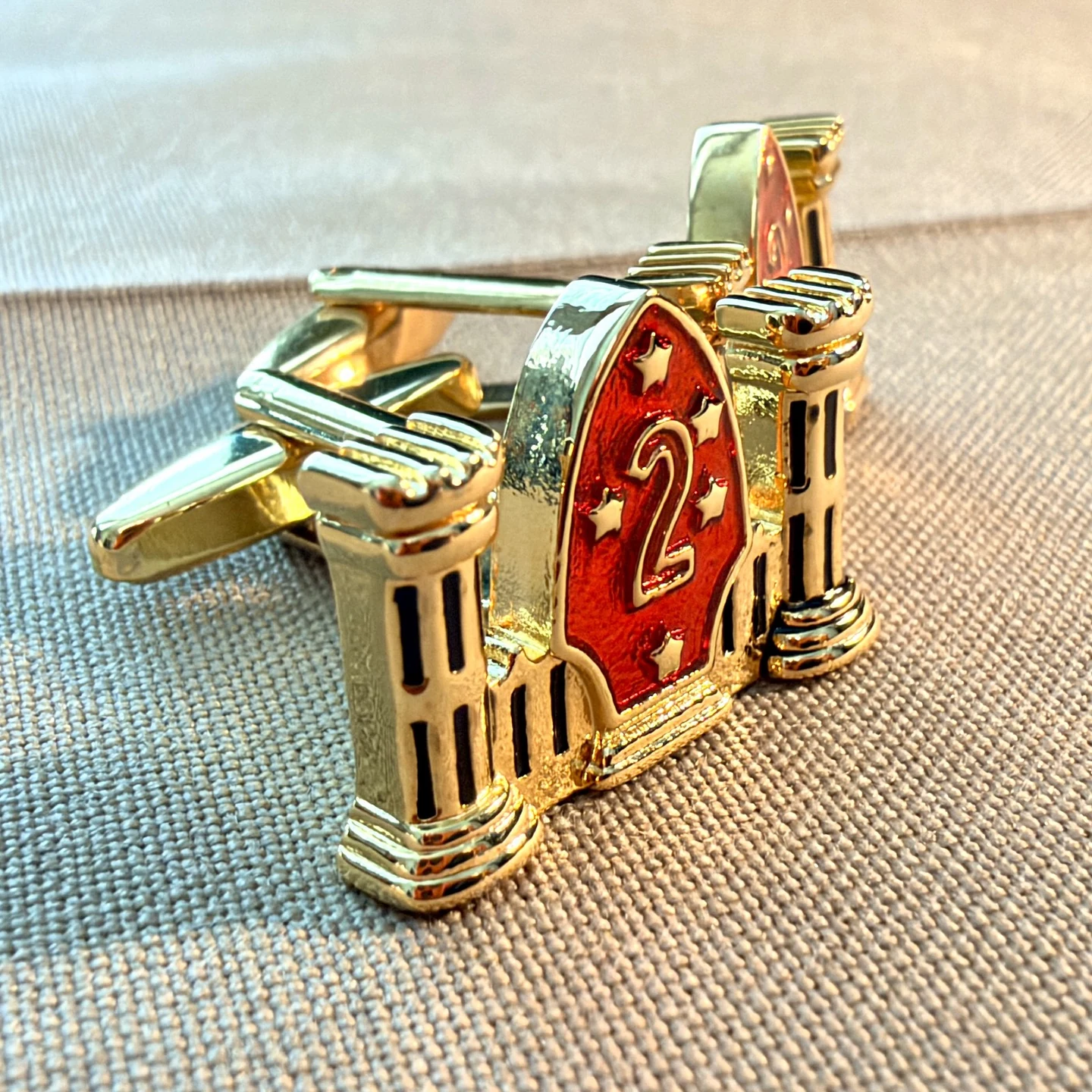 Actual 2nd Combat Engineer Battalion cufflinks showing the small castle insignia and fastening hardware on khaki fabric