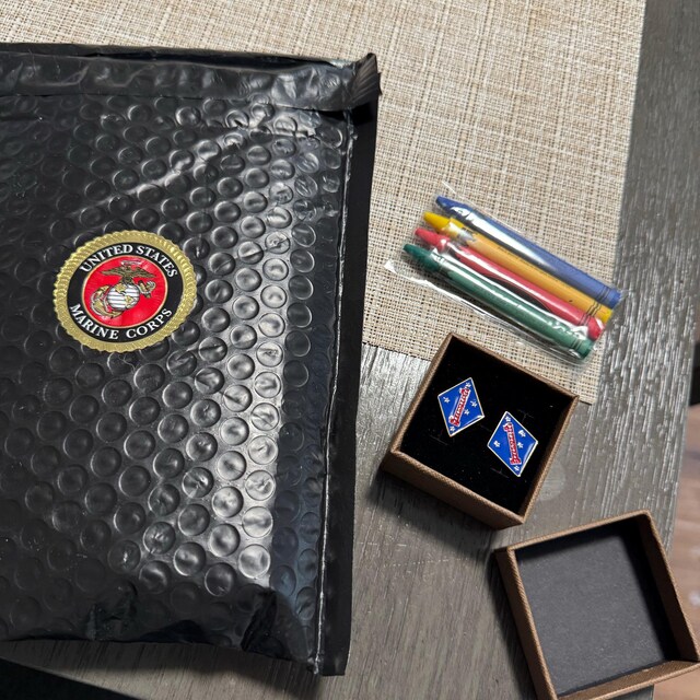 Anthony’s photo of his 1st Marine Division cufflinks, presentation box, Marine Corps packaging, and crayons.