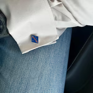 Timothy’s photo of a blue 1st Marine Division cufflink on a white shirt cuff.